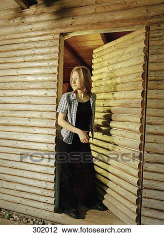 Woman at entrance of log cabin View Large Photo Image Stock Image - Woman at entrance of log cabin. Fotosearch