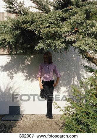 Woman stood in shade below tree View Large Photo Image Stock Photo - Woman stood in shade below tree. Fotosearch