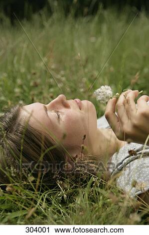 Close-up of girl lying in grass View Large Photo Image Stock Image - Close-up of girl lying in grass. Fotosearch