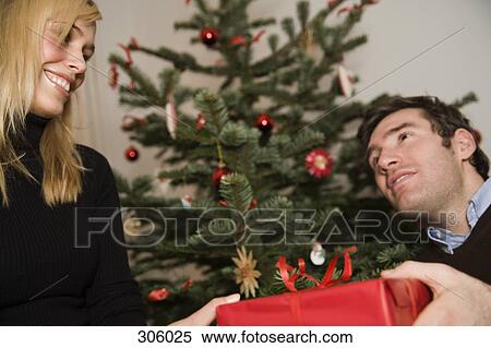 Couple exchanging gift at Christmas View Large Photo Image Stock Photography - Couple exchanging gift at Christmas. Fotosearch