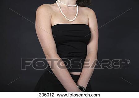 Stock Image - Mid section of woman wearing tube top. Fotosearch