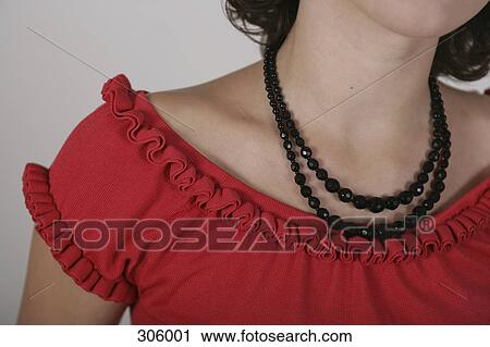 Stock Image - Shoulders and neck of woman wearing necklace. Fotosearch