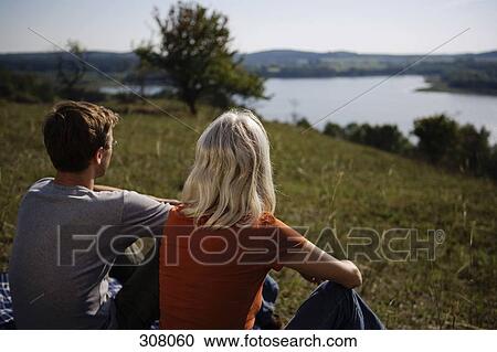 Couple sitting looking at view View Large Photo Image Stock Image - Couple sitting looking at view. Fotosearch