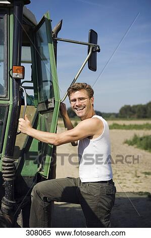 Farm worker climbing into tractor and smiling View Large Photo Image Stock Photography - Farm worker climbing into tractor and smiling. Fotosearch