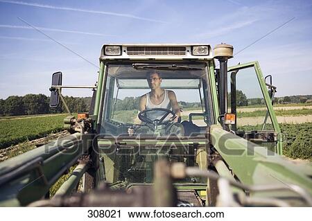 Farmer driving tractor in field View Large Photo Image Stock Image - Farmer driving tractor in field. Fotosearch