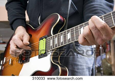 Close-up of guitarist playing guitar View Large Photo Image Stock Image - Close-up of guitarist playing guitar. Fotosearch