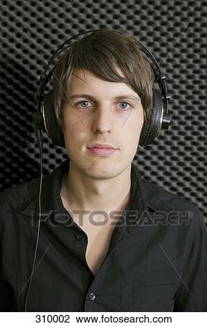 Man wearing headphones in sound recording studio View Large Photo Image Stock Image - Man wearing headphones in sound recording studio. Fotosearch