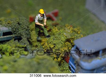 Model of manual worker standing near abandoned cars View Large Photo Image Stock Photograph - Model of manual worker standing near abandoned cars. Fotosearch