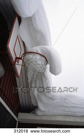 Stock Photo - Snow covered roof and basketball ring. Fotosearch