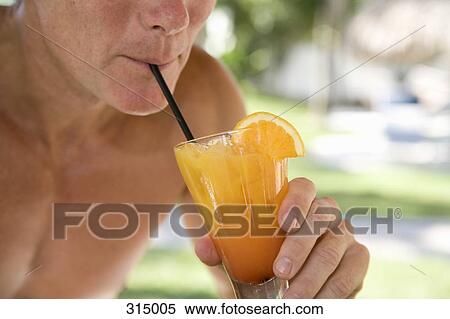 Stock Photography - Man drinking juice on vacation. Fotosearch