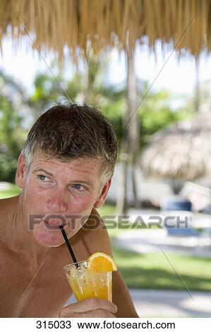 Man drinking orange drink on holiday View Large Photo Image Stock Image - Man drinking orange drink on holiday. Fotosearch