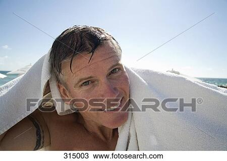Man drying himself on the beach View Large Photo Image Stock Image - Man drying himself on the beach. Fotosearch