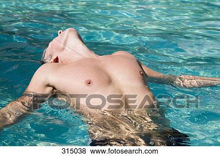 Stock Photo - Man floating on back in swimming pool. Fotosearch