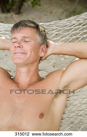 Man lying down on hammock View Large Photo Image Stock Image - Man lying down on hammock. Fotosearch
