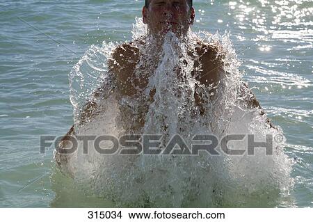 Man making splash in sea View Large Photo Image Picture - Man making splash in sea. Fotosearch