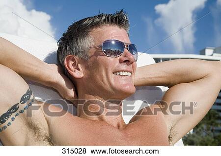 Stock Photo - Man sunbathing and smiling. Fotosearch