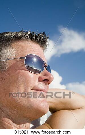 Man sunbathing and wearing sunglasses View Large Photo Image Stock Image - Man sunbathing and wearing sunglasses. Fotosearch