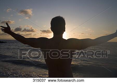 Silhouette of man in front of sunset with arms outstretched View Large Photo Image Stock Photo - Silhouette of man in front of sunset with arms outstretched. Fotosearch