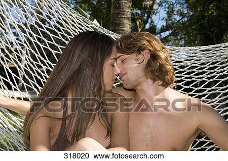 Young couple kissing in hammock View Large Photo Image Stock Image - Young couple kissing in hammock. Fotosearch