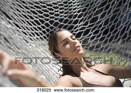 Stock Photography - Young woman resting in hammock. Fotosearch