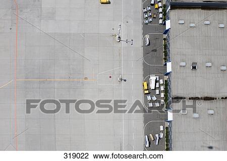 Stock Image - Aerial view of empty airport tarmac and luggage carts. Fotosearch