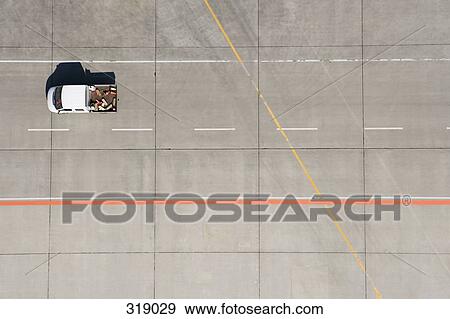 Aerial view of van driving across airport tarmac View Large Photo Image Stock Photo - Aerial view of van driving across airport tarmac. Fotosearch