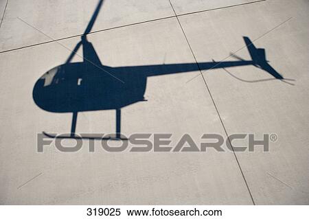 Shadow of a helicopter on airport tarmac View Large Photo Image Stock Photography - Shadow of a helicopter on airport tarmac. Fotosearch