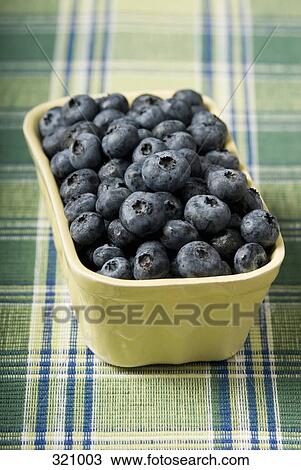 Stock Image - Bowl full of blueberries on checked tablecloth. Fotosearch