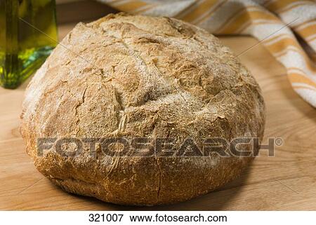 Stock Photo - Loaf of bread on wooden bench. Fotosearch