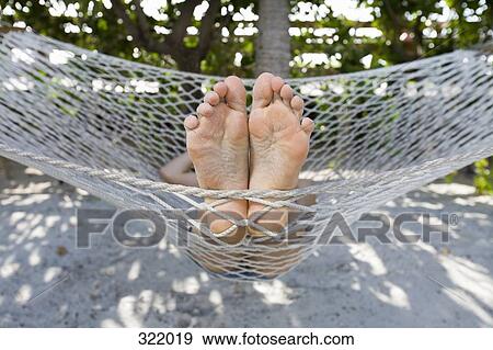 Close up of person’s feet lying in hammock View Large Photo Image Stock Photo - Close up of person’s feet lying in hammock. Fotosearch