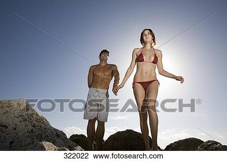 Couple walking across rocks and holding hands View Large Photo Image Stock Image - Couple walking across rocks and holding hands. Fotosearch
