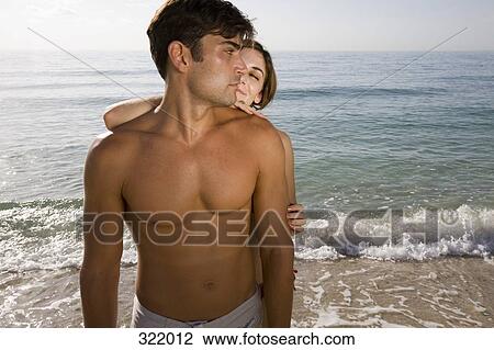 Woman standing behind man on beach View Large Photo Image Stock Image - Woman standing behind man on beach. Fotosearch
