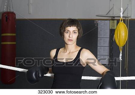 Female boxer leaning on ropes of boxing ring View Large Photo Image Stock Image - Female boxer leaning on ropes of boxing ring. Fotosearch