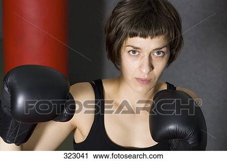 Female boxer standing in gym with raised fists View Large Photo Image Stock Image - Female boxer standing in gym with raised fists. Fotosearch