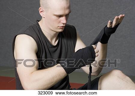 Male boxer wrapping strap around hand View Large Photo Image Stock Photo - Male boxer wrapping strap around hand. Fotosearch