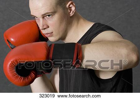 Young male boxer standing with fists raised View Large Photo Image Stock Photo - Young male boxer standing with fists raised. Fotosearch