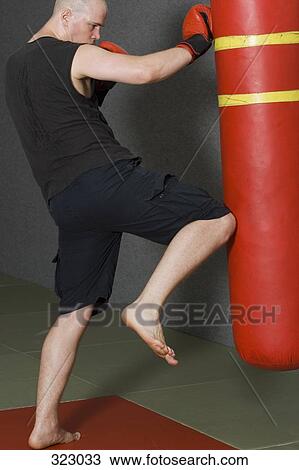 Young man kickboxing in gym View Large Photo Image Stock Image - Young man kickboxing in gym. Fotosearch