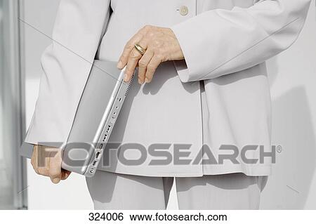 Stock Photograph - Businesswoman holding a laptop computer. Fotosearch