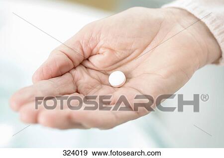 Stock Photo - Woman holding tablet in palm of hand. Fotosearch