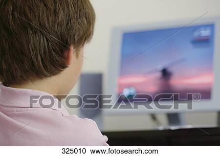 Stock Image - Boy playing games on desktop computer. Fotosearch