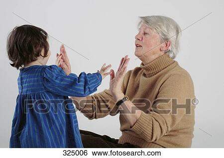 Woman clapping hands with young girl View Large Photo Image Stock Photograph - Woman clapping hands with young girl. Fotosearch