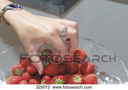 Woman picking strawberry from glass bowl View Large Photo Image Stock Image - Woman picking strawberry from glass bowl. Fotosearch