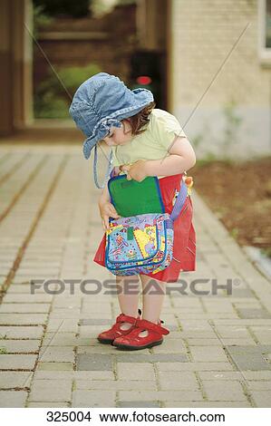 Young girl looking through shoulder bag View Large Photo Image Picture - Young girl looking through shoulder bag. Fotosearch