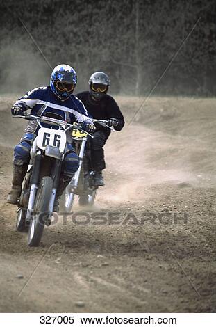 Two people racing motorcycles on dirt track View Large Photo Image Stock Photography - Two people racing motorcycles on dirt track. Fotosearch