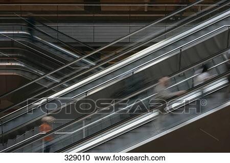 Stock Image - People moving up escalator. Fotosearch