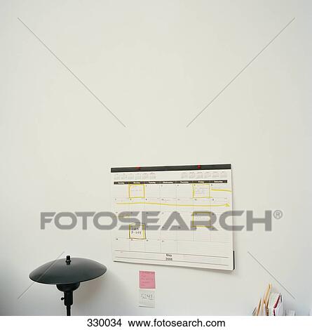 Calendar attached to wall above desktop View Large Photo Image Picture - Calendar attached to wall above desktop. Fotosearch