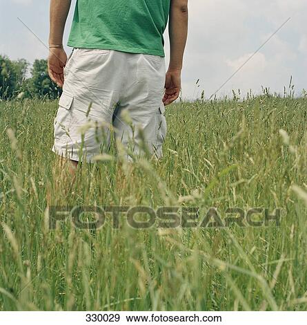 Stock Photo - Man standing in field of grass. Fotosearch