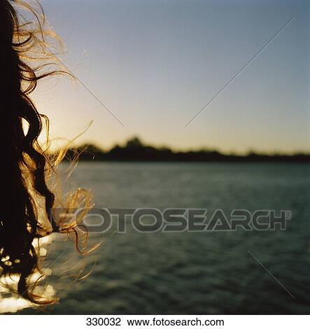 Woman looking at sunset over water View Large Photo Image Stock Image - Woman looking at sunset over water. Fotosearch
