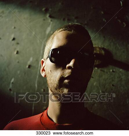 Young man wearing sunglasses in shadow View Large Photo Image Stock Image - Young man wearing sunglasses in shadow. Fotosearch