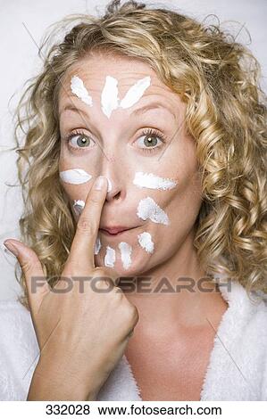 Woman applying moisturizer looking surprised View Large Photo Image Stock Photo - Woman applying moisturizer looking surprised. Fotosearch